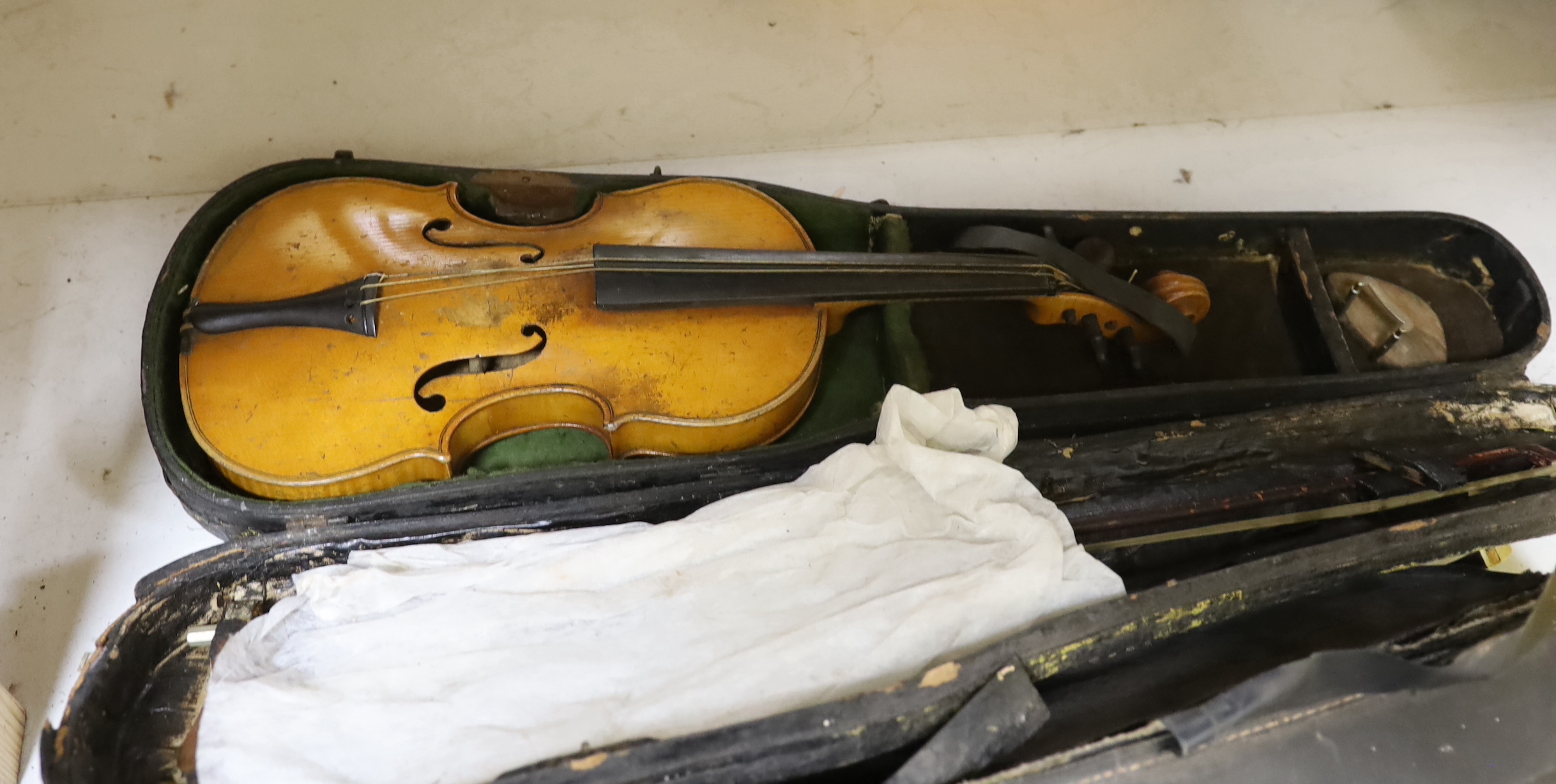 A violin, labelled Giovan Paulo Maggini, and three other violins, with bows in cases